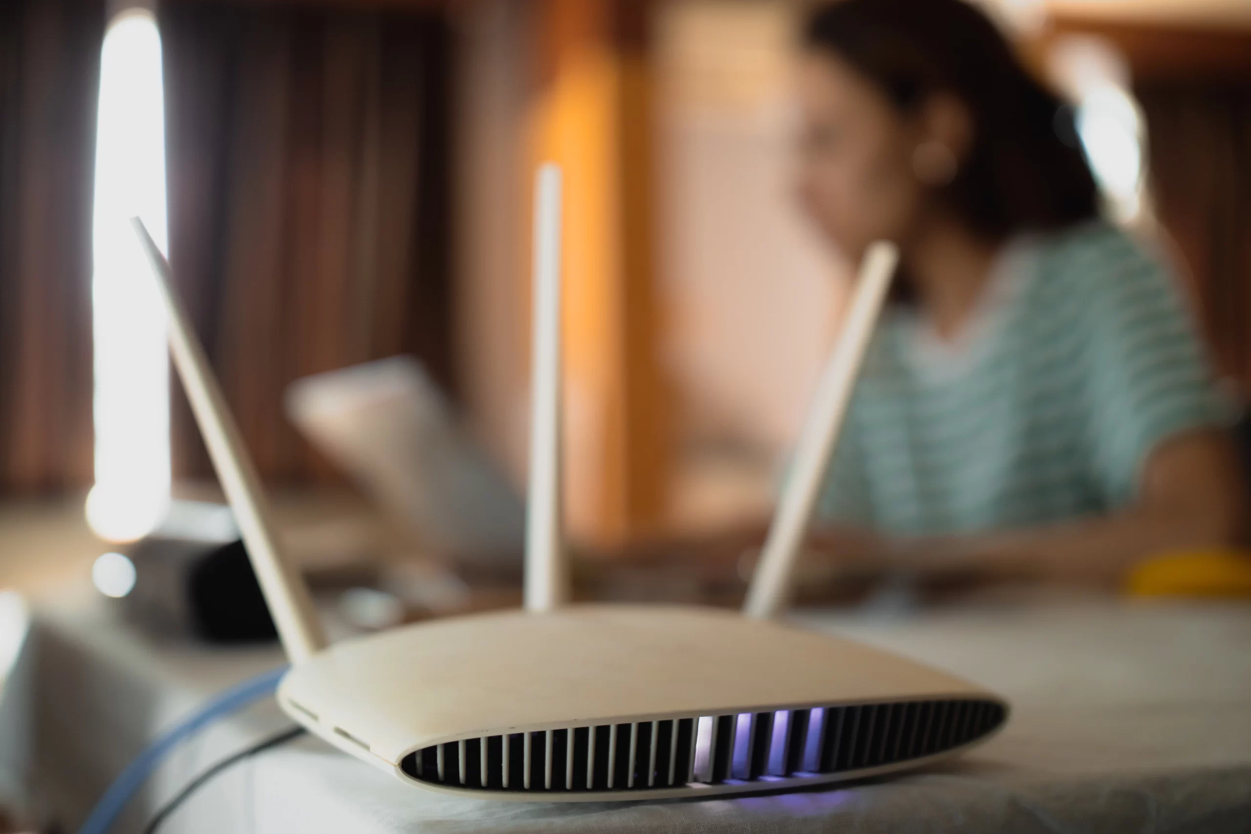 a woman is working at home using a travel router