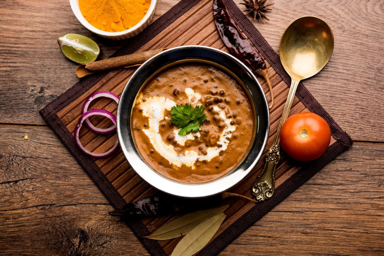 A bowl of dal-makhani on a serving board