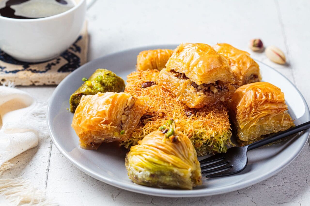 Fresh assorted baklava on gray plate, gray tiles background