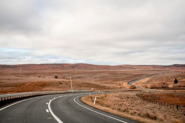 Open empty road surrounded by fields and farms in Outback Australia