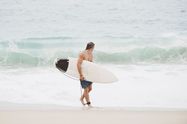 australian-surfer-with-surfboard-on-beach