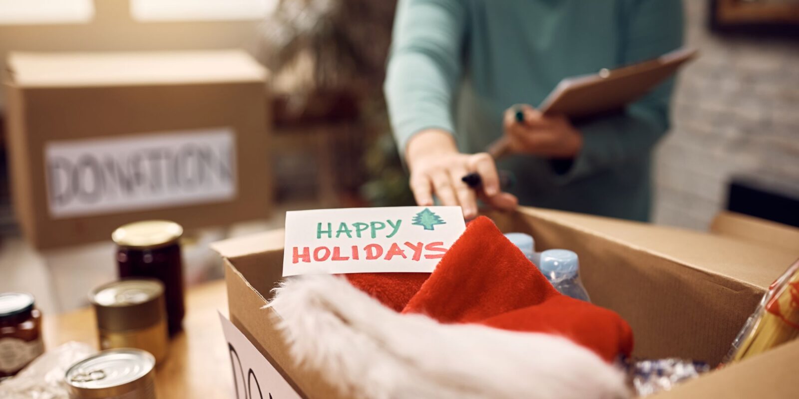 Close-up of woman preparing donation boxes during post holiday decluttering