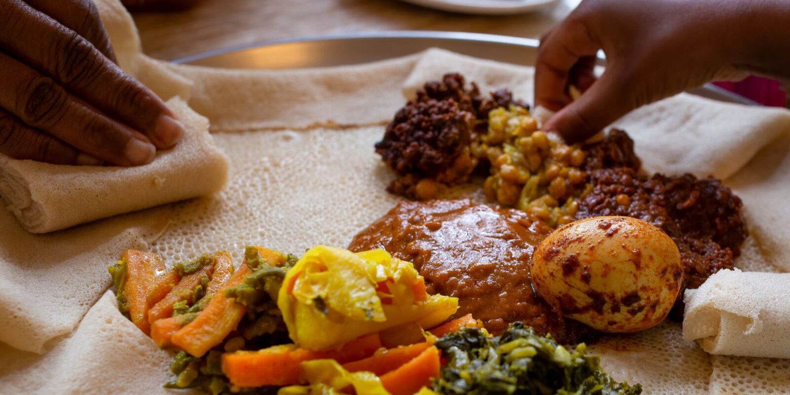 Vegetarian Injera meal with shiro, lentils and egg -