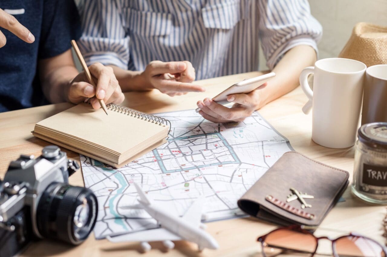 Young couple doing Family Road Trip Planning - planning vacation trip