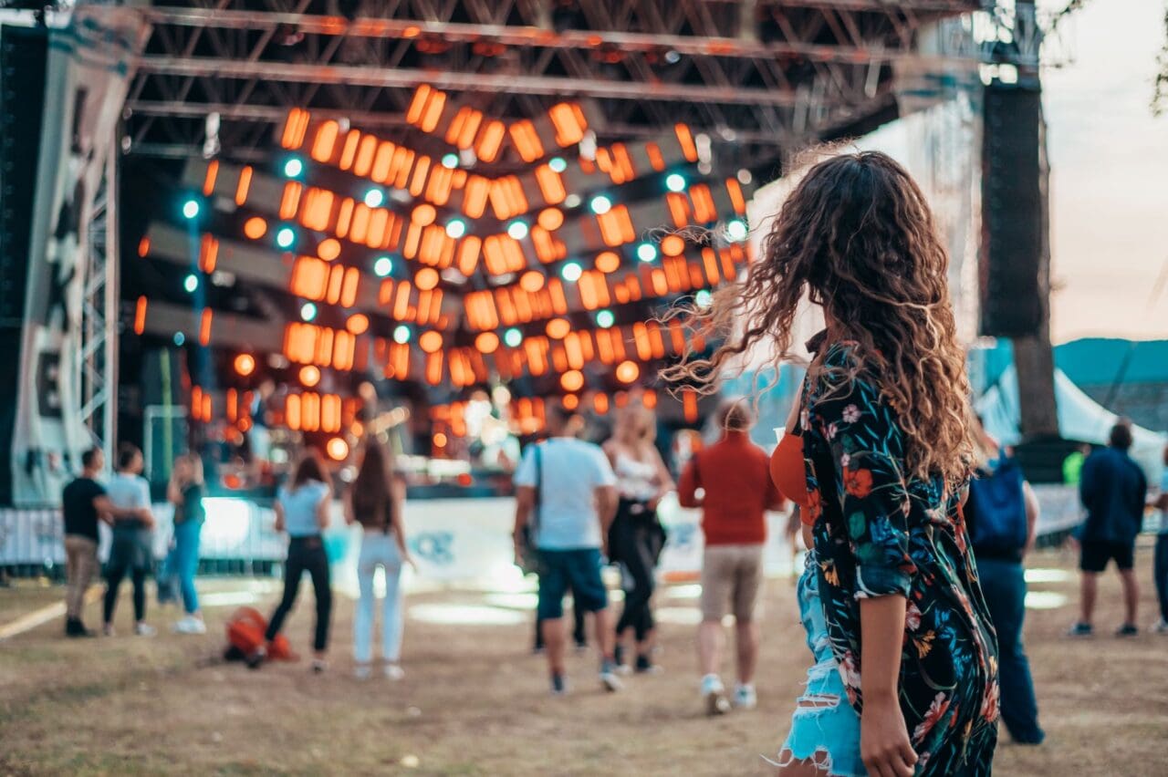 Beautiful woman drinking beer and having fun on a festival with her friends